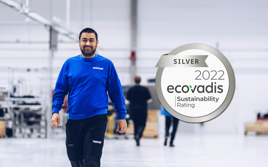 Glad medarbetare i Micropowers batterifabrik med logo Ecovadis